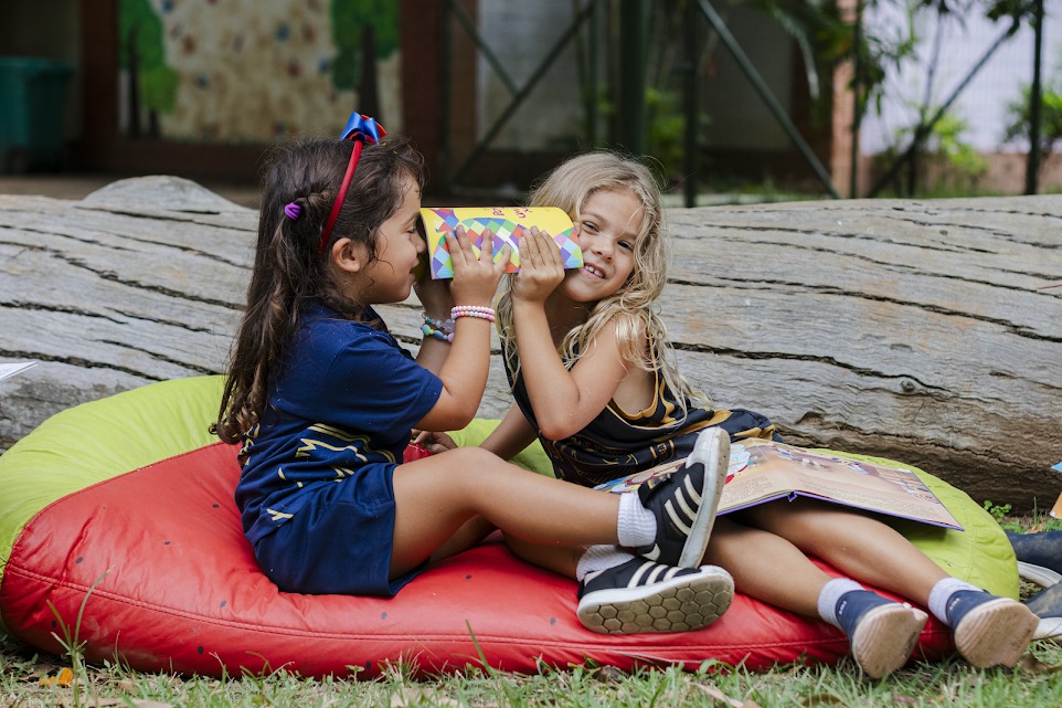 Crianças da Educação Infantil explorando materiais em atividade ao ar livre