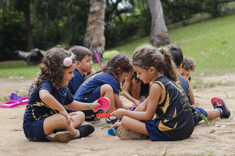 Crianças da Educação Infantil brincando com areia em área externa