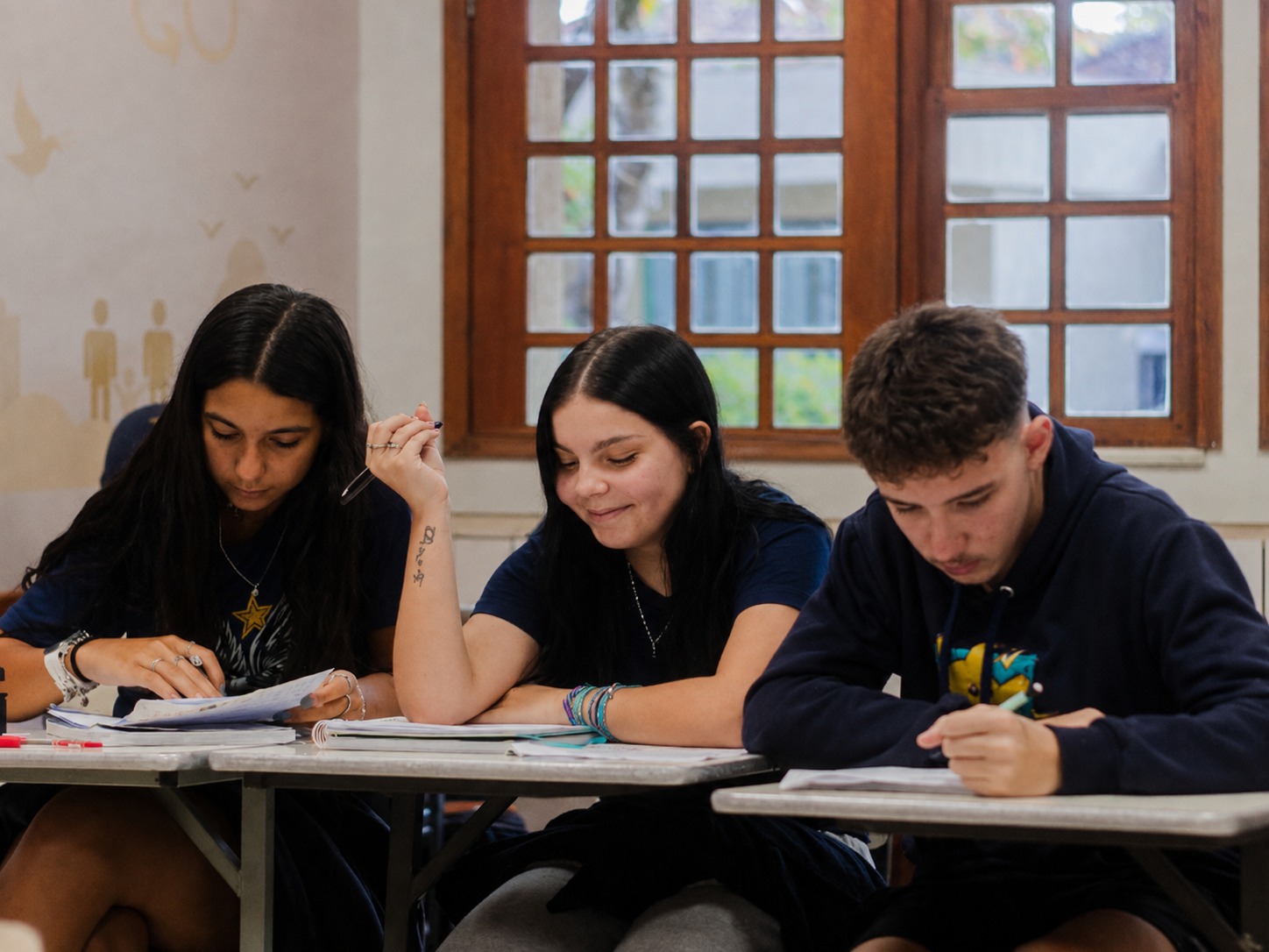 Estudantes do Ensino Médio realizando atividade escrita em sala de aula